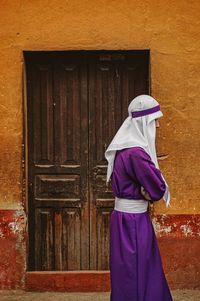 Rear view of woman standing against closed door of building