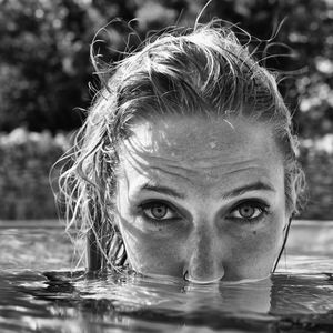 Close-up portrait of smiling young woman in swimming pool