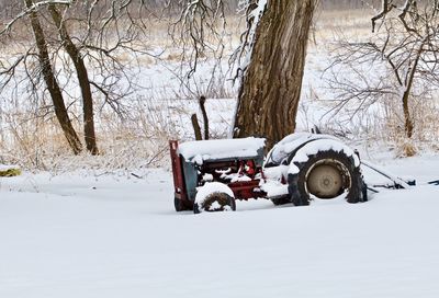 Snow covered car on field