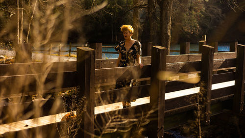 Rear view of woman standing by fence