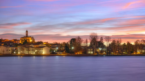 Illuminated buildings in city at sunset