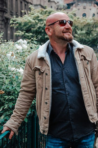 Portrait of young man standing against plants