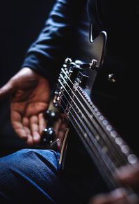 Midsection of man playing guitar