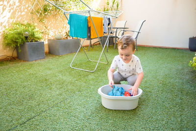 Boy playing with teddy bear in yard