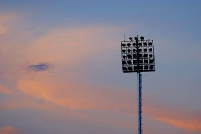 Low angle view of floodlight against sky during sunset