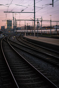 Railroad tracks against sky at sunset