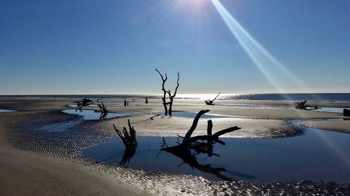 Scenic view of beach against clear blue sky