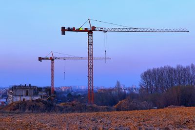 Low angle view of crane against clear blue sky