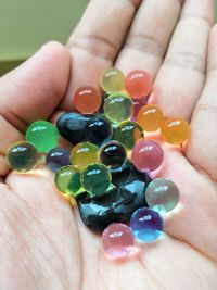 Close-up of hand holding multi colored candies