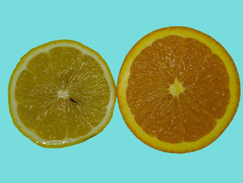Close-up of lemon slice on table against blue background