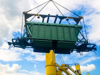 Low angle view of crane at construction site against sky