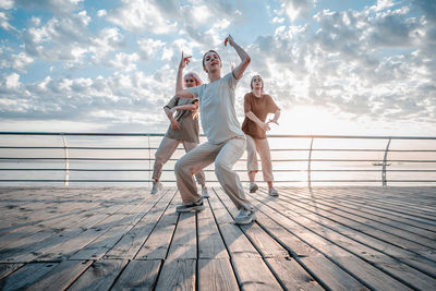 Man jumping on railing against sky