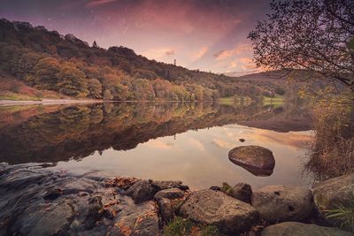 Scenic view of lake against sky at sunset