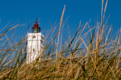 Low angle view of lighthouse on beach against sky