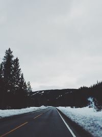 Road passing through snow covered landscape