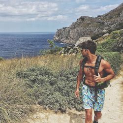 Full length of man standing at beach against sky