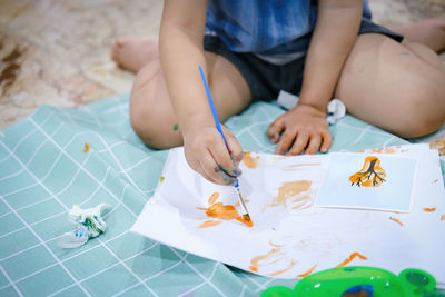 High angle view of girl sitting on table