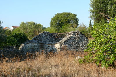 Abandoned building on field against clear sky