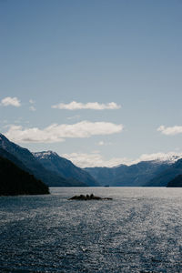 Scenic view of lake by snowcapped mountains against sky