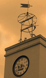 Low angle view of weather vane against sky