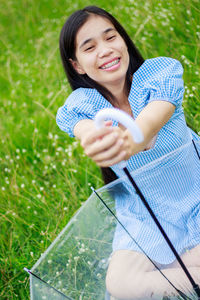 Smiling young woman sitting on field