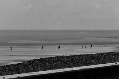 People on beach against sky