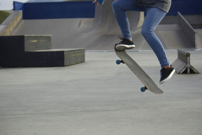 Low section of woman skateboarding at park