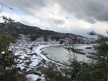 Scenic view of lake by mountains against sky