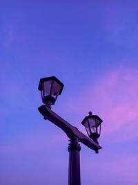 Low angle view of illuminated street light against blue sky