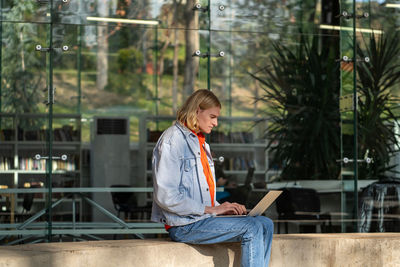 Portrait of young man standing against building