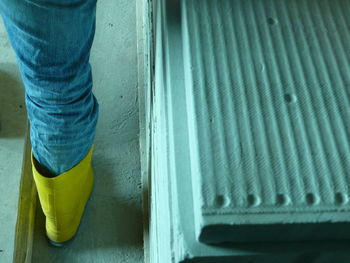 Low section of worker wearing rubber boot at construction site