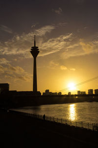 Sunset over river with buildings in background