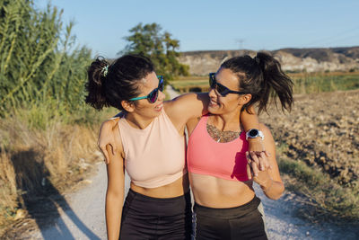 Happy woman and instructor wearing sunglasses on sunny day