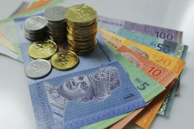 High angle view of coins and currency on table