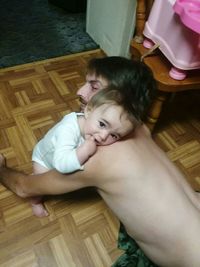 High angle portrait of baby girl on hardwood floor at home