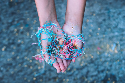 Cropped hand of girl holding colorful confetti