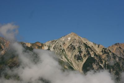 Scenic view of mountains against clear blue sky