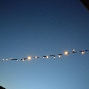 Low angle view of illuminated lights against blue sky at night