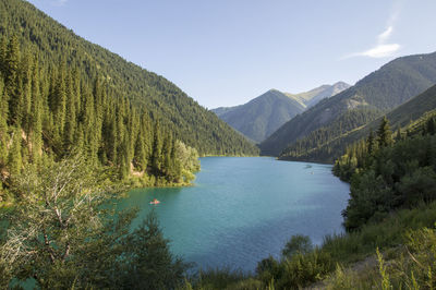 Scenic view of lake by mountains against sky