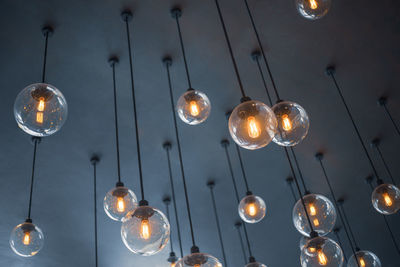 Low angle view of light bulb hanging on ceiling