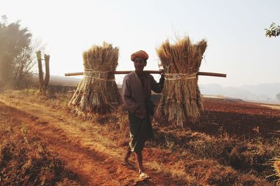 Man standing on agricultural field against sky