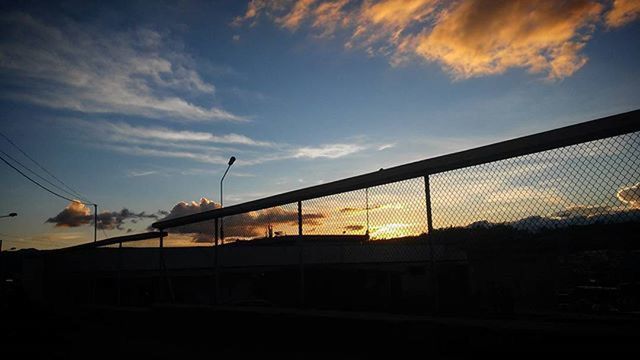 sunset, sky, built structure, architecture, silhouette, cloud - sky, orange color, building exterior, cloud, low angle view, connection, railing, no people, nature, power line, outdoors, fence, house, dusk, cloudy