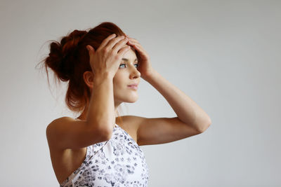 Portrait of beautiful young woman against white background