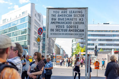 People on street against buildings in city