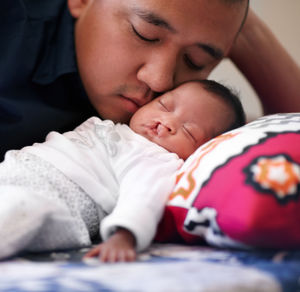 Father embracing daughter on bed