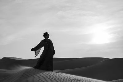 Rear view of silhouette man standing against sky