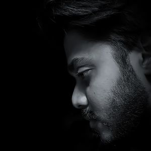 Close-up of young man against black background