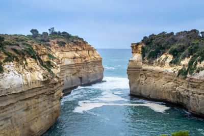 Rock formations by sea against sky