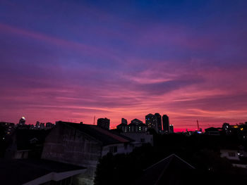High angle view of silhouette buildings against sky during sunset