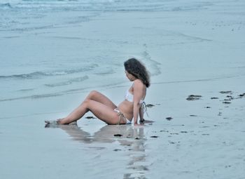 Full length of young woman on beach